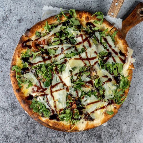 Barrel 28's fig and prosciutto pizza, topped with arugula, shaved parmesan, and balsamic glaze.
