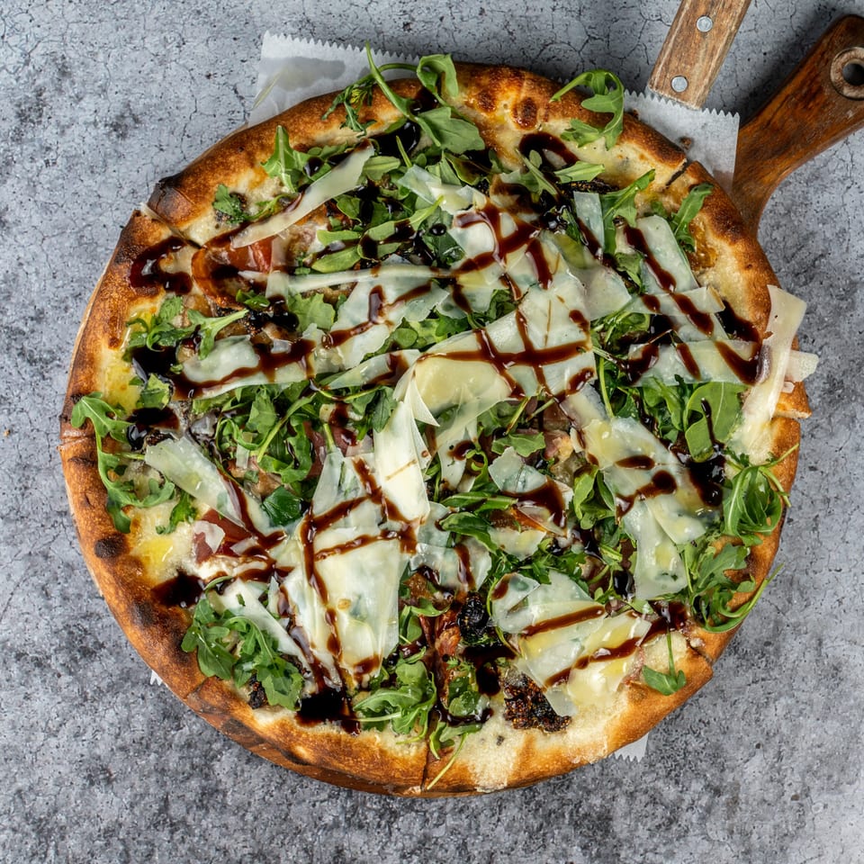 Barrel 28's fig and prosciutto pizza, topped with arugula, shaved parmesan, and balsamic glaze.