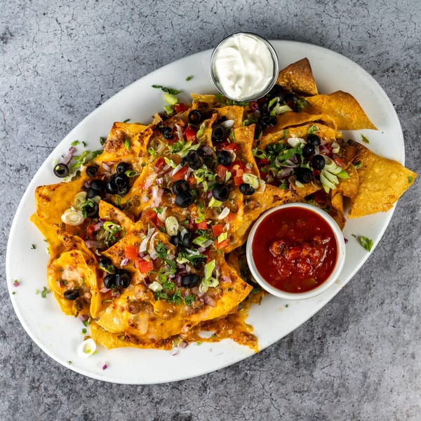 Barrel 28 nachos with melted cheese, black olives, tomatoes, onions, and salsa and sour cream.