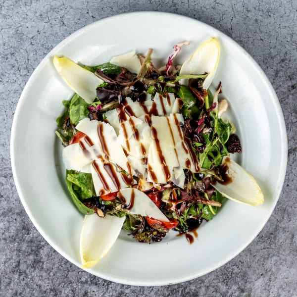 Barrel 28's mixed green salad with shaved parmesan, cherry tomatoes, endive, and balsamic glaze.