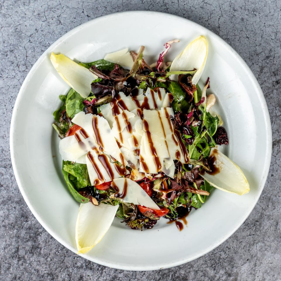 Barrel 28's mixed green salad with shaved parmesan, cherry tomatoes, endive, and balsamic glaze.
